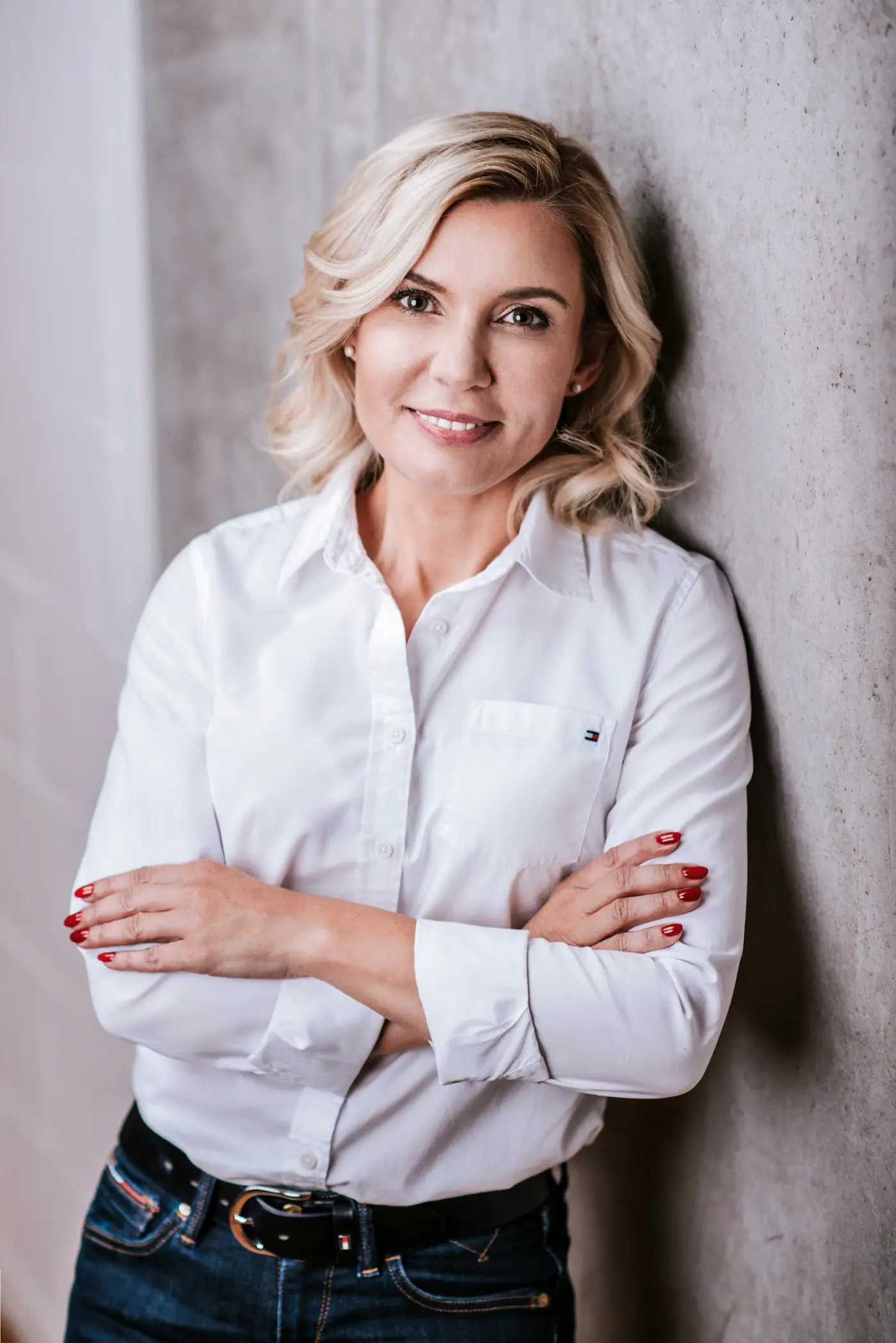 Ewa Pędzich-Ościłowska w&nbsp;białej koszuli stoi ze skrzyżowanymi rękami, ilustrując audyt ubezpieczeniowy.